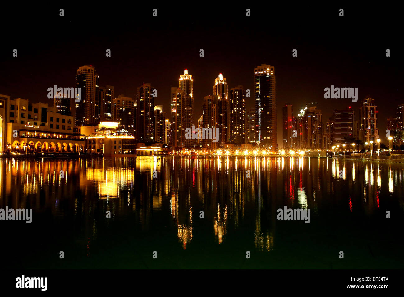 I grattacieli di Dubai e altri edifici di notte, vista dall'acqua Foto Stock