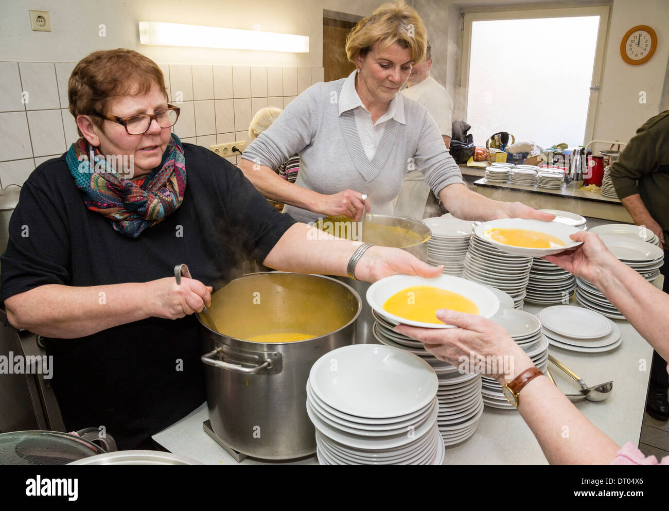 Volontari di una comunità della Chiesa locale le piastre di riempimento con la zuppa di zucca, che è servita come una cena di Natale per i senzatetto Foto Stock