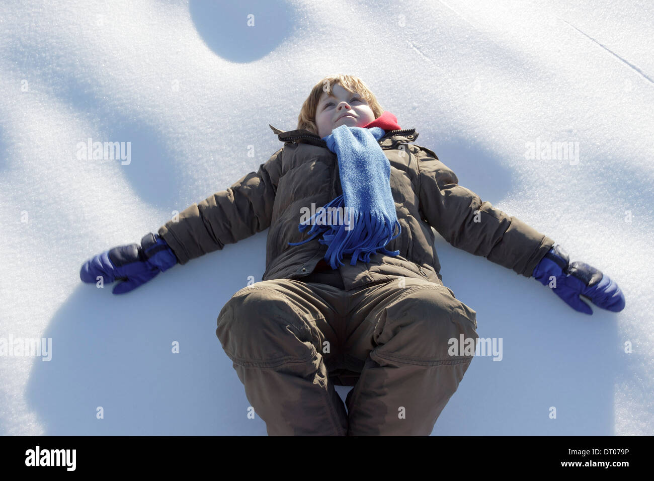 Giovane ragazzo disteso sulla neve congelate su Kahler Asten vicino a Winterberg, Sauerland, Renania Settentrionale - Westfalia, Germania Foto Stock