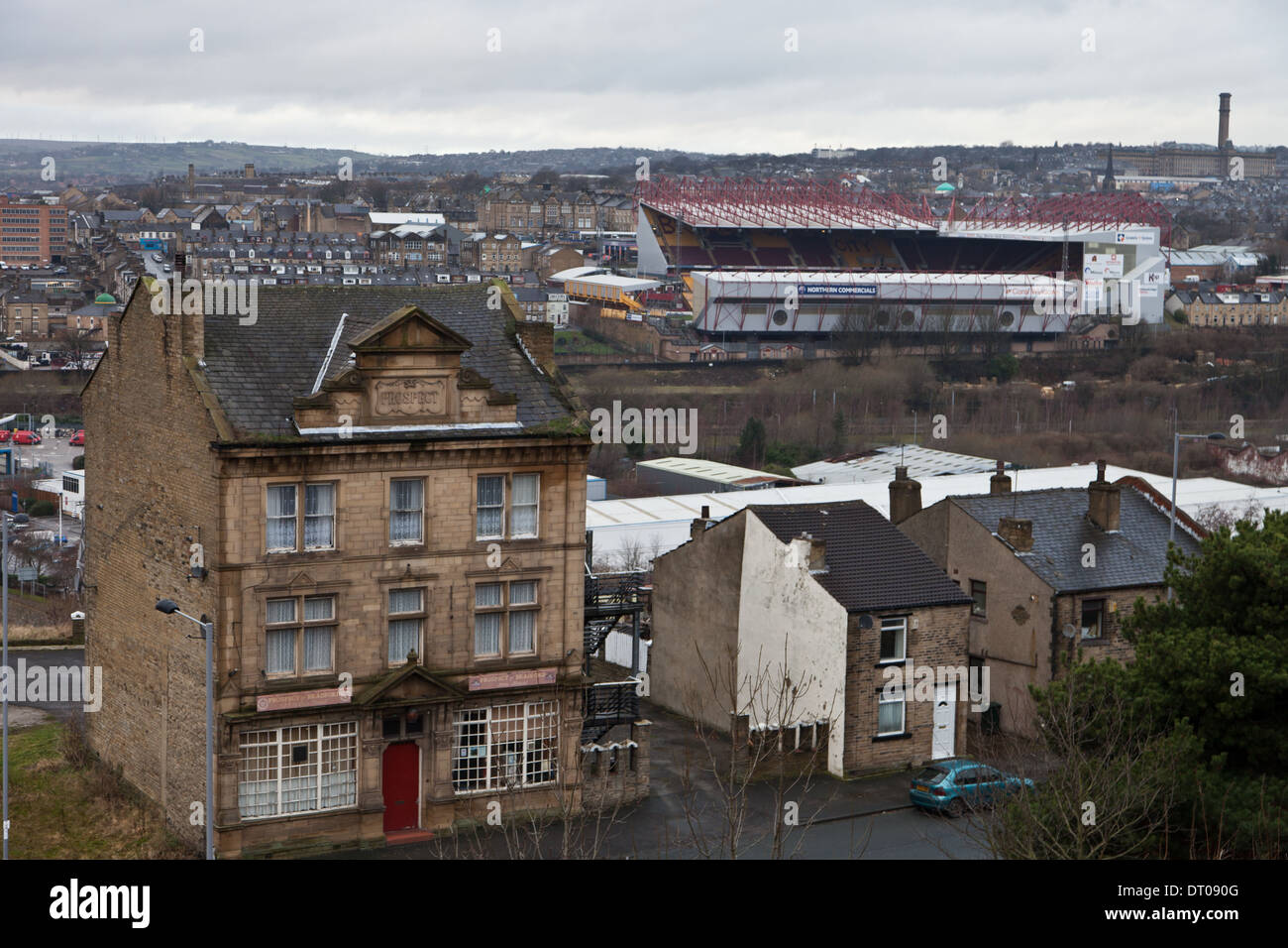 Bradford City Football Ground, Valley Parade, una vista da una lontana collina con un pub in primo piano e case in pietra Foto Stock