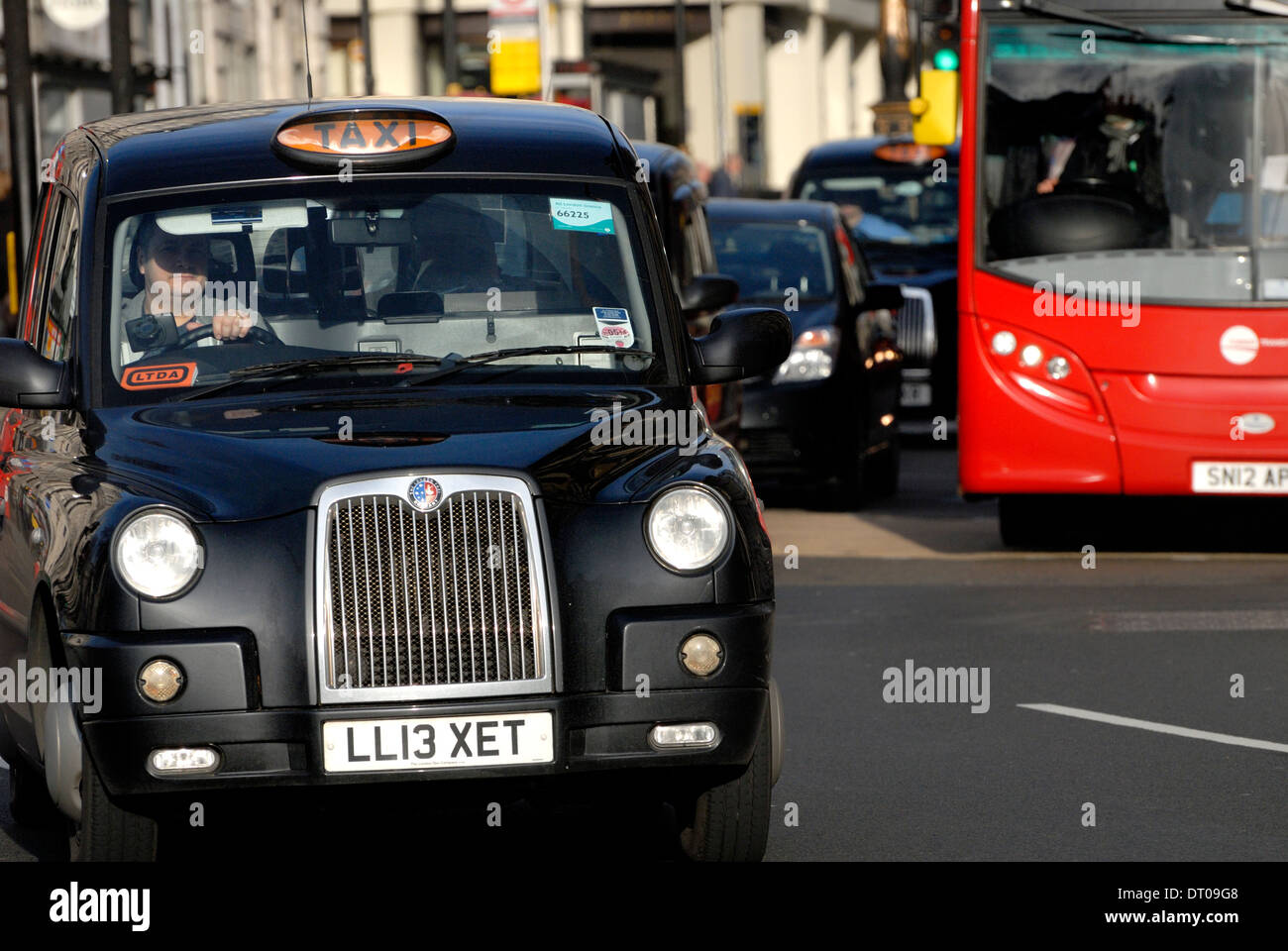 Londra, Inghilterra, Regno Unito. London Black Cab taxi e bus rosso Foto Stock
