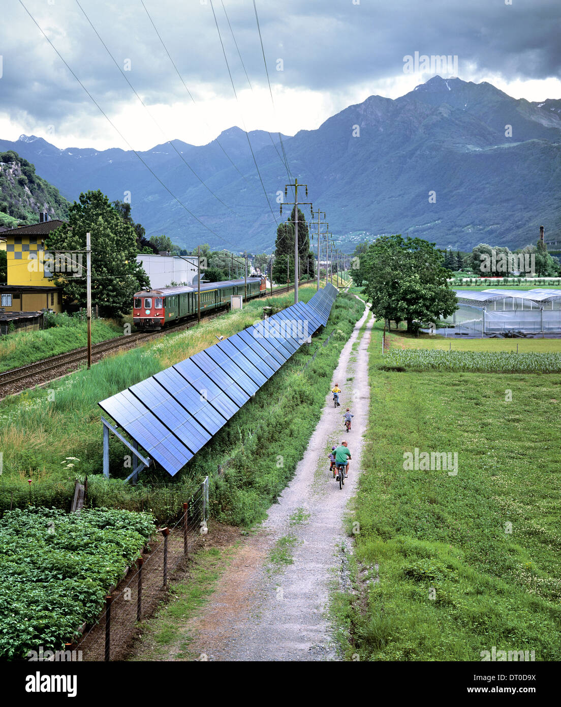 Un array di grid-connected celle fotovoltaiche la generazione di elettricità solare, a fianco di una linea ferroviaria nel sud della Svizzera. Foto Stock