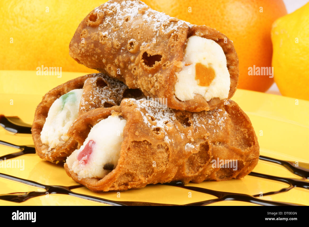 Close-up di originale mini cannoli siciliani su una piastra di colore giallo. Foto Stock