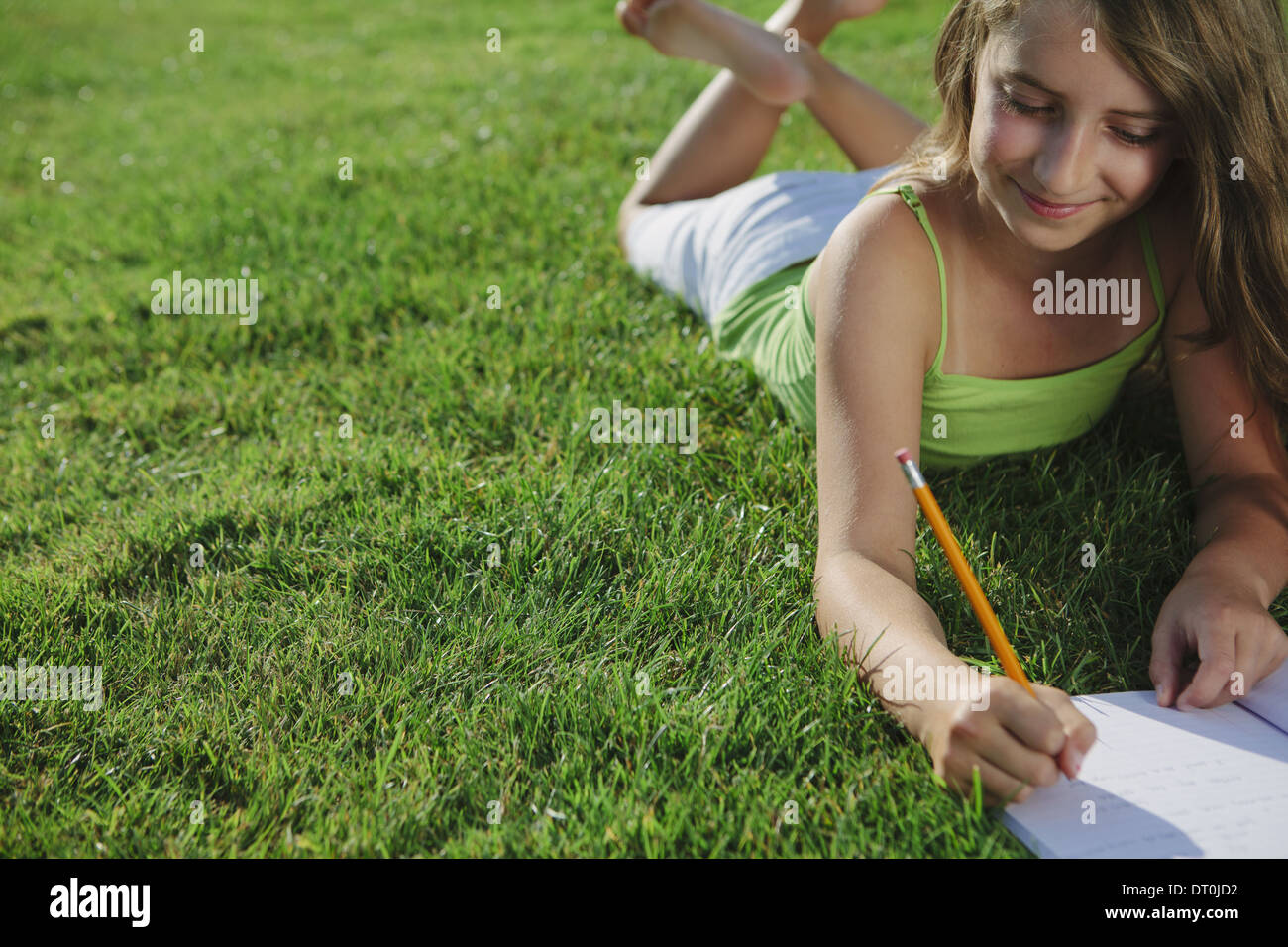 Seattle Washington USA sorridente ragazza sulla scrittura di erba in notebook Foto Stock