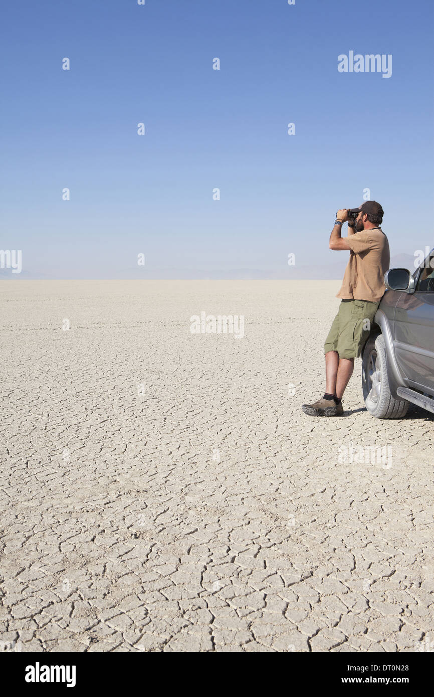 Black Rock Desert Nevada USA uomo nel deserto secco guardando attraverso il binocolo Foto Stock