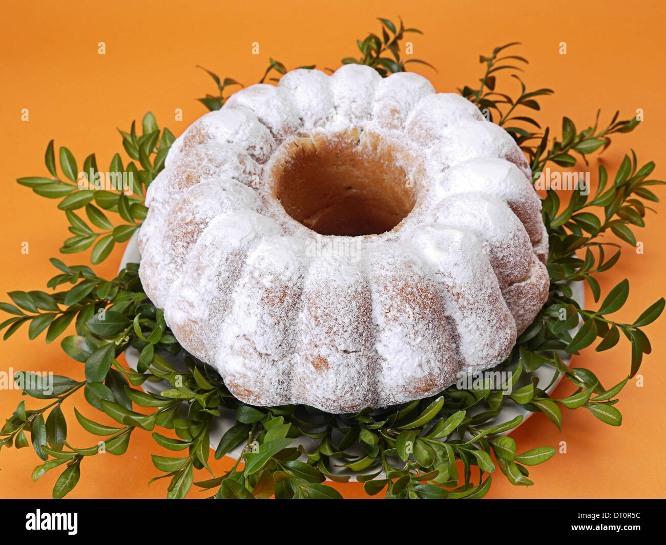 Tradizionale Torta di Pasqua spolverati con zucchero a velo su sfondo arancione Foto Stock