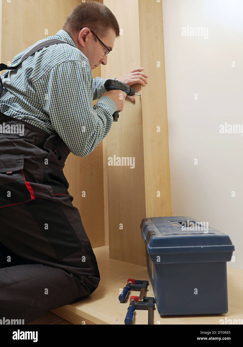 Carpenter montaggio mobili guardaroba in armadio a muro Foto Stock