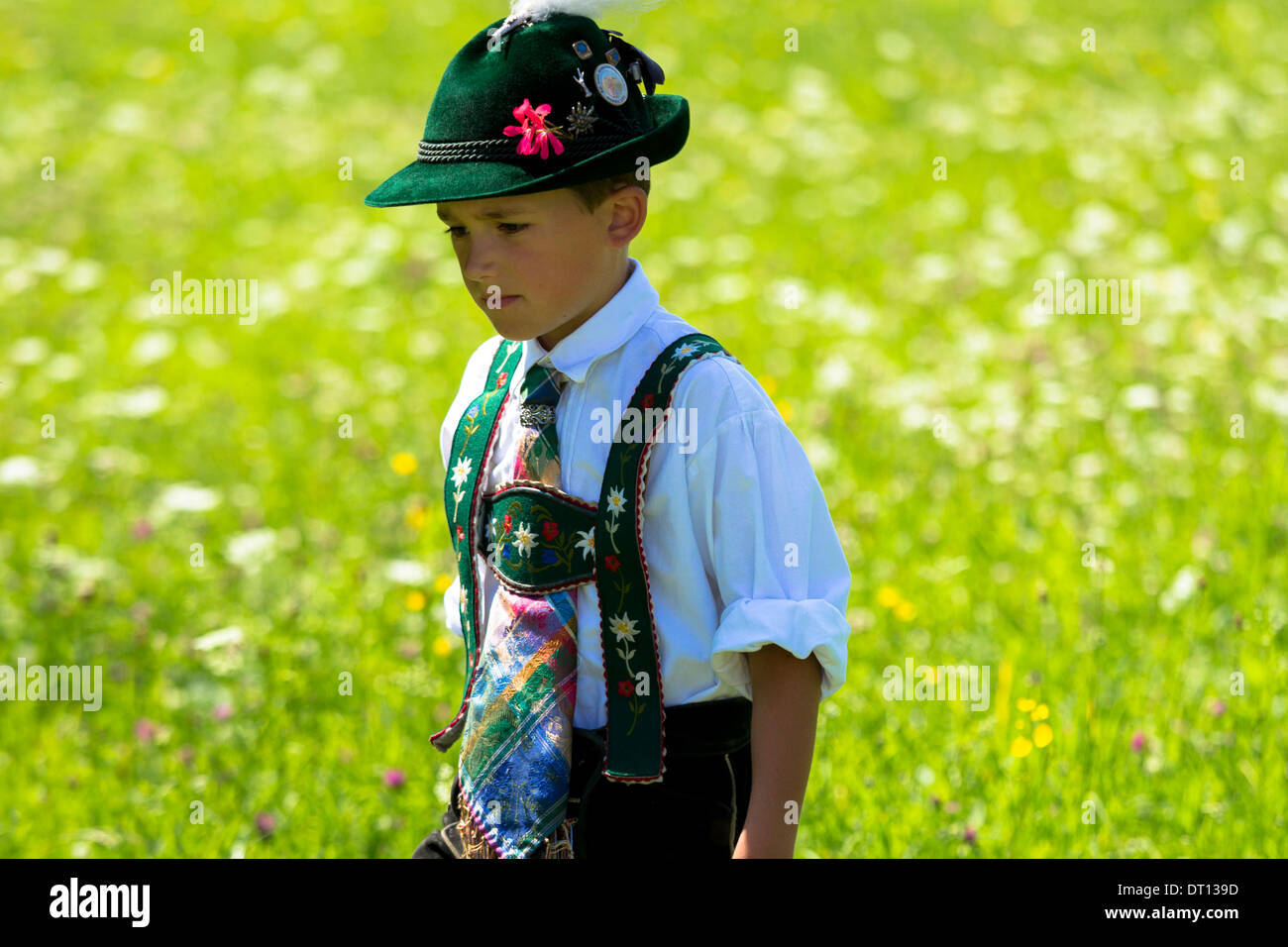 Giovane ragazzo in costume passeggiate attraverso prati di fiori durante la tradizionale festa della birra nel villaggio di Klais in Baviera, Germania Foto Stock