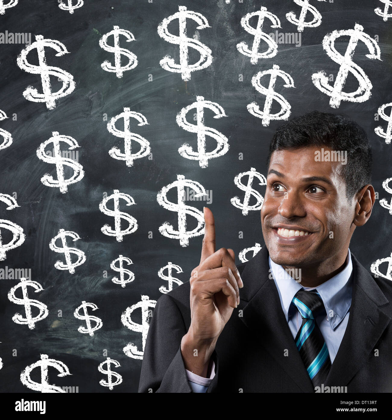 Felice Indian business man rivolti a segni di dollaro su una scheda di gesso. Foto Stock