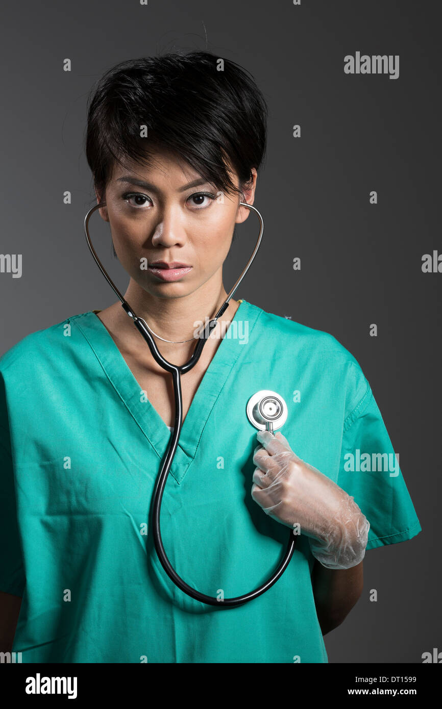 L'infermiere regola il fonendoscopio sul collo del medico Foto stock - Alamy
