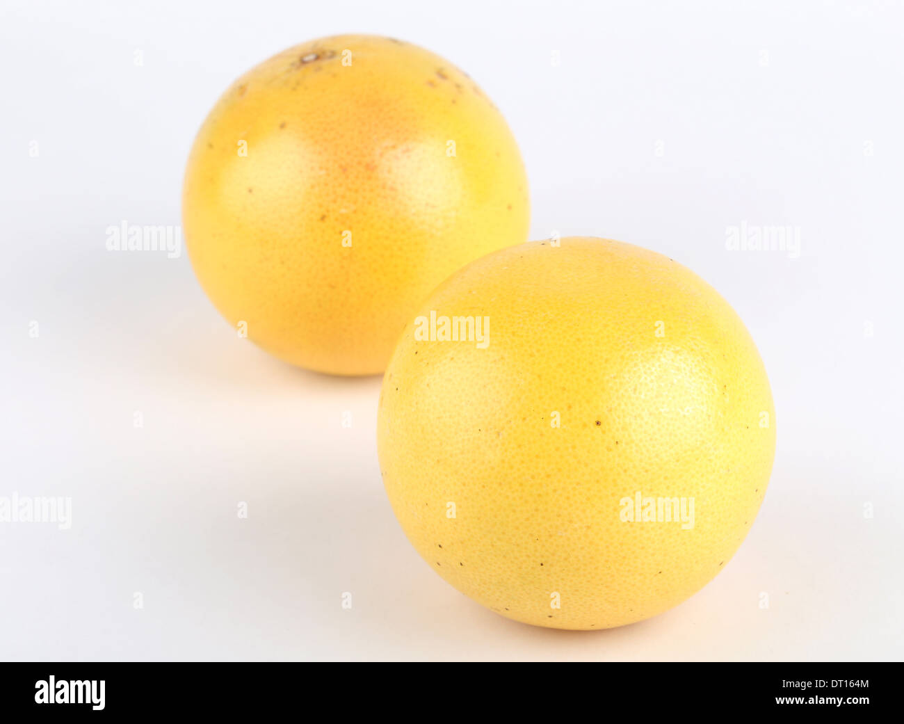 Mature di pompelmo e di metà isolato su bianco Foto Stock