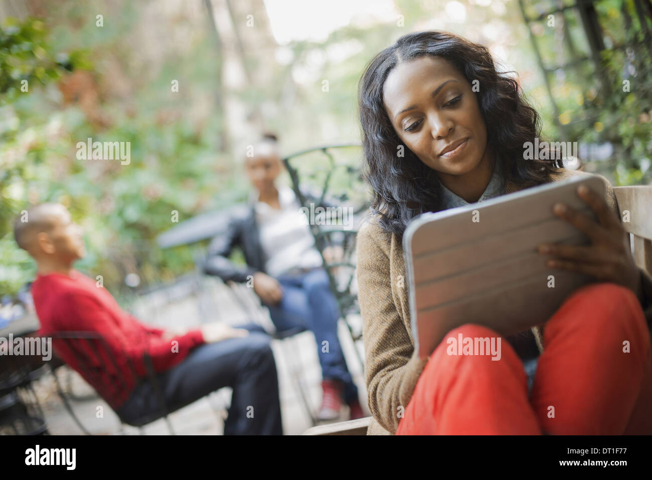 Scene di vita urbana della città di New York all'aperto due persone in background una donna che utilizza un computer tablet o pad Foto Stock