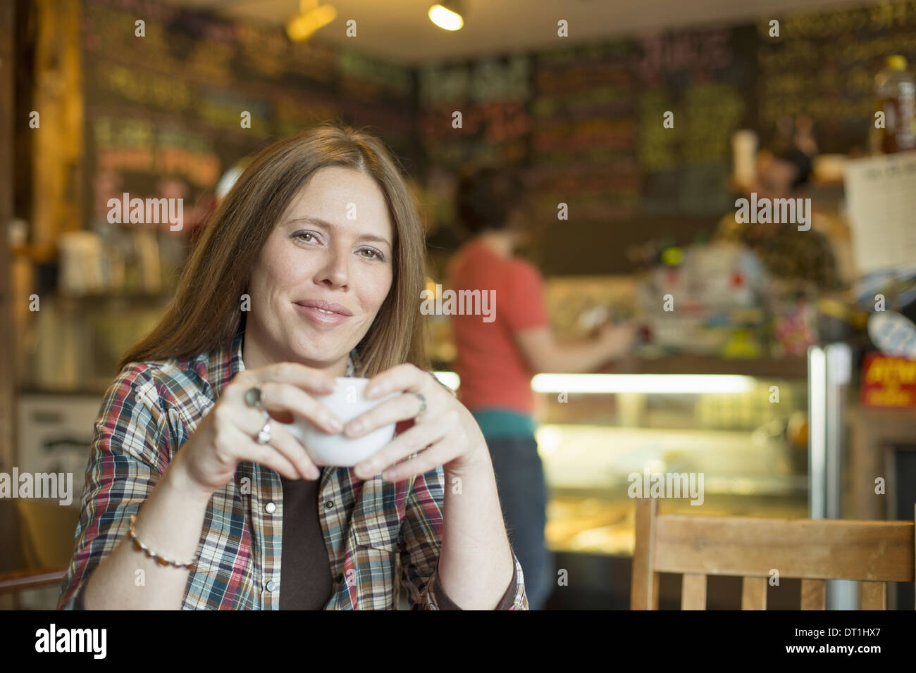 Un coffee shop e caffetteria in alte cascate chiamato l'ultimo boccone due persone in background e una donna seduta al tavolo Foto Stock