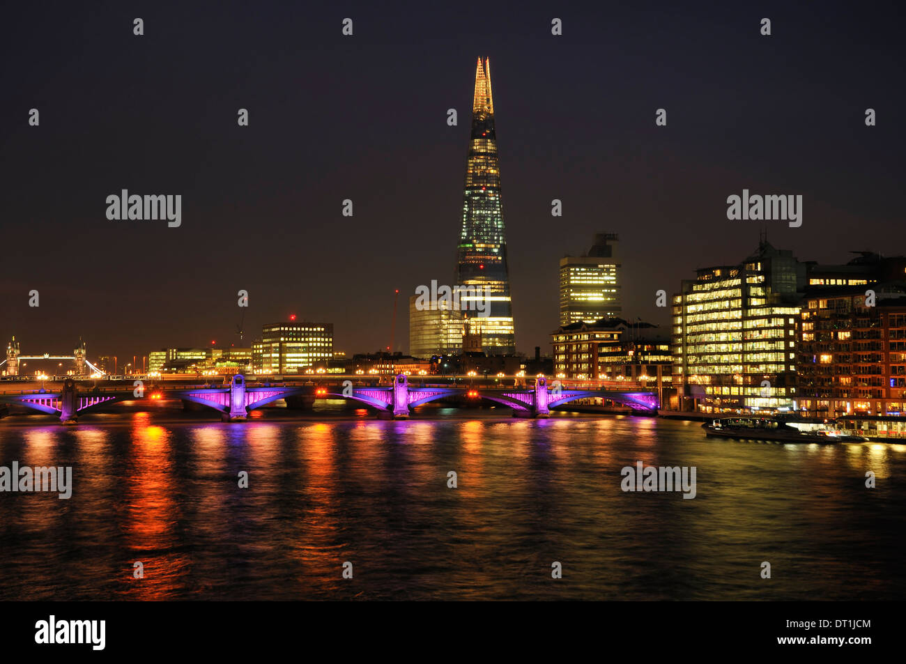 La South Bank, Londra UK, di notte, illuminata, con il ponte Shard e Southwark Foto Stock