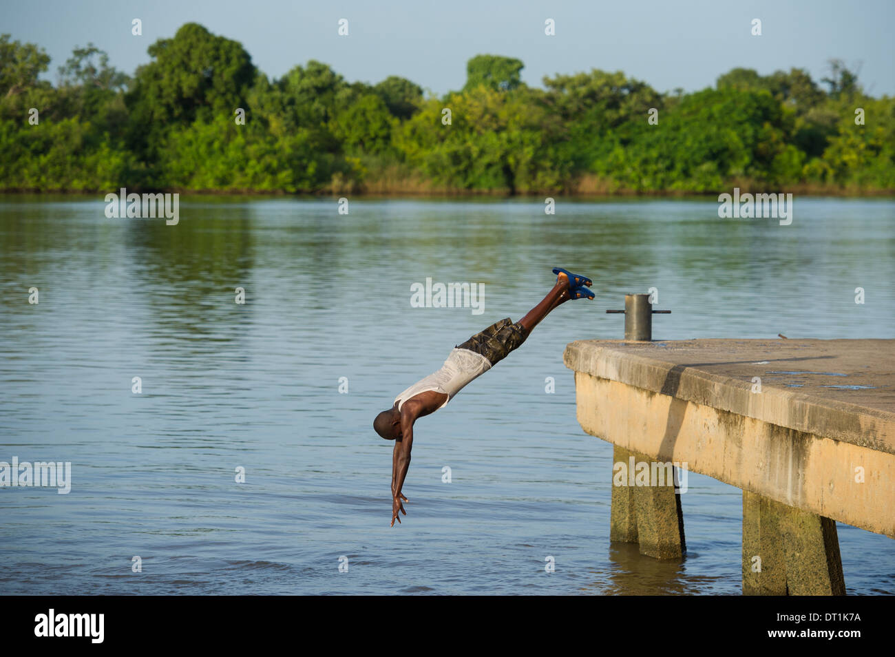 Ragazzo le immersioni nel fiume Gambia dal molo, Janjangbureh sull isola MacCarthy, Gambia Foto Stock