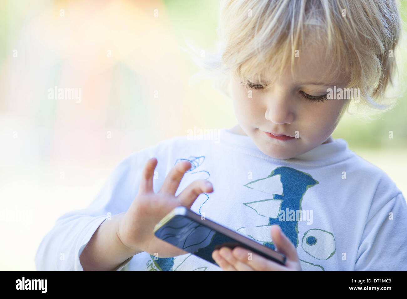 Little Boy giocando con lo smartphone Foto Stock