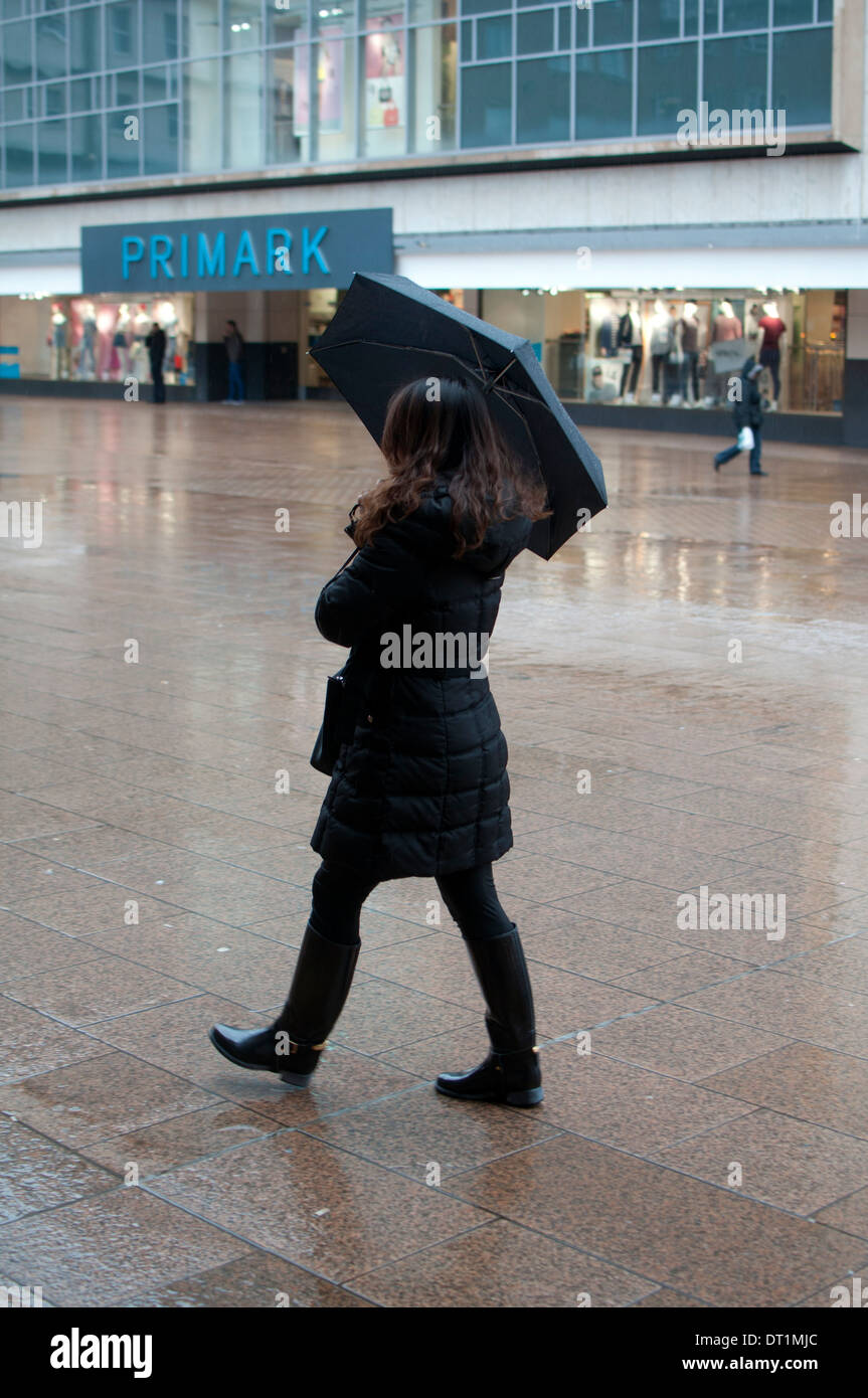 Piove, città del Regno Unito. Donna con ombrello fino e altre persone fuori  shopping e attraversando la strada sotto la pioggia, Nottingham,  Inghilterra, Regno Unito Foto stock - Alamy