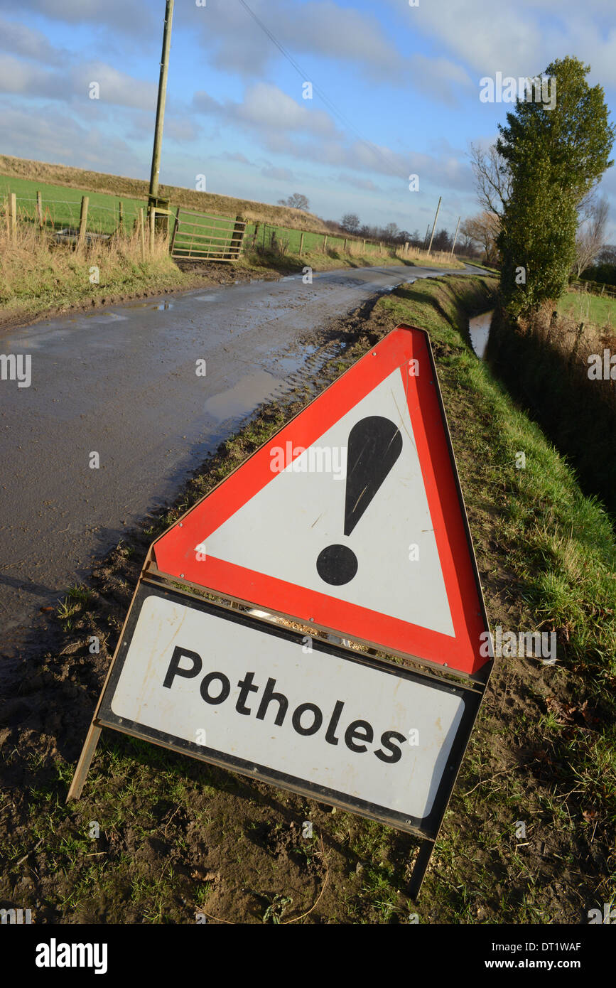 Segno di avvertimento di buche nella strada del paese regno unito Foto Stock