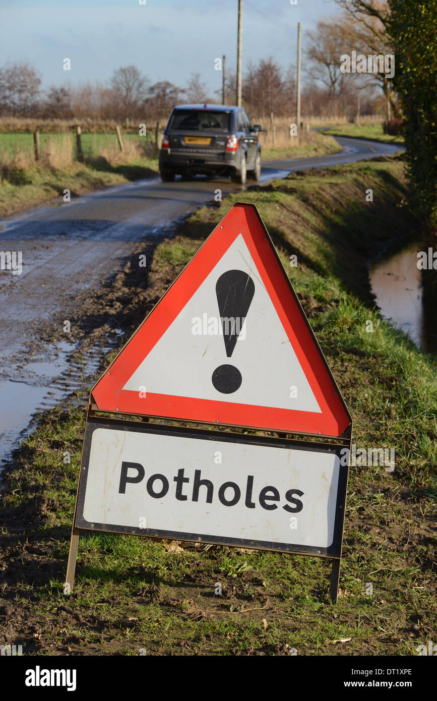 La trazione a quattro ruote motrici veicolo transitante cartello segnaletico di buche sulla strada di campagna Yorkshire Regno Unito Foto Stock
