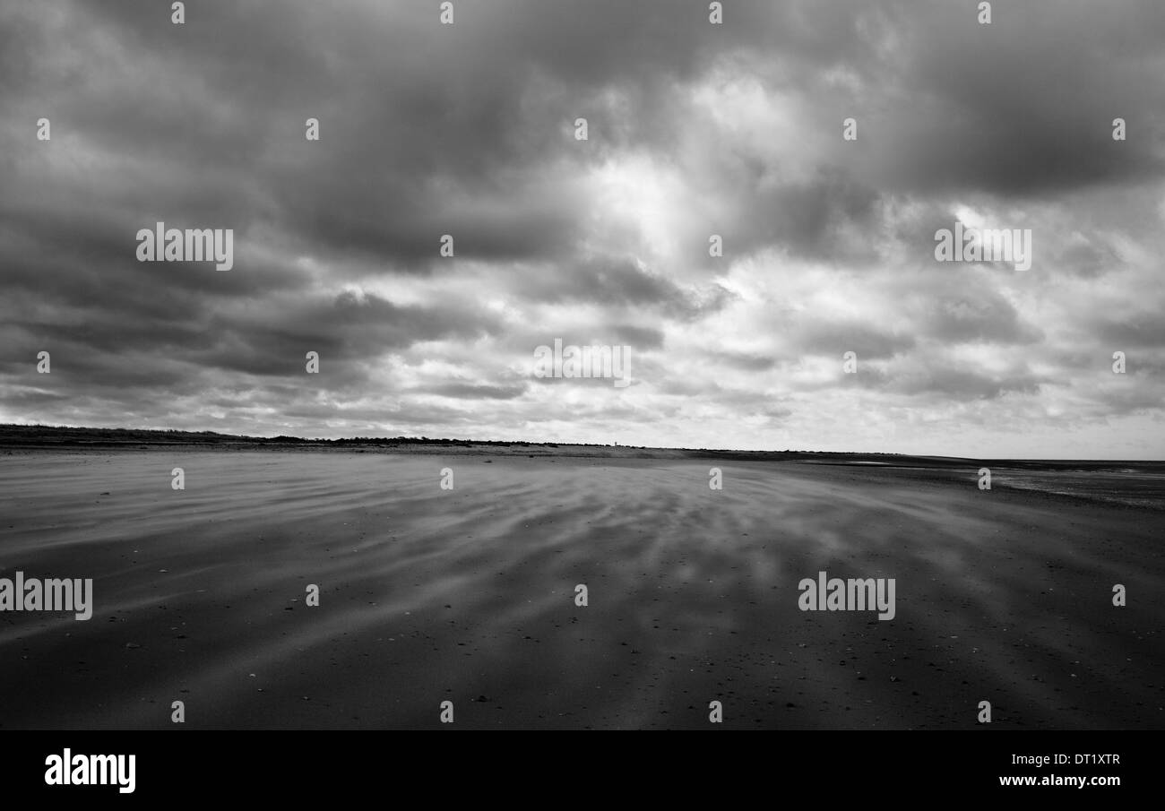 Guardando verso il vecchio Hunstanton da Holme-next-il-mare sulla costa di Norfolk con sabbia soffiando nel vento forte. Foto Stock