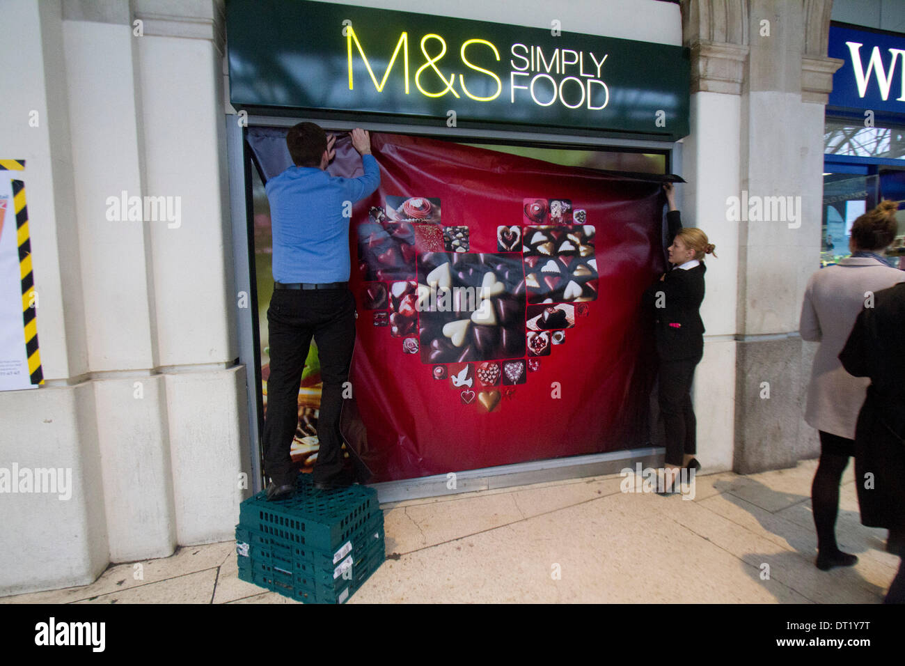 Londra REGNO UNITO. 6 febbraio 204. Il personale di Marks & Spencer mettere un poster al cioccolato a forma di cuore scatola come negozi pronti per il giorno di San Valentino che è associato con l'amore romantico da decorare windows shop fronti con cuori Credito: amer ghazzal/Alamy Live News Foto Stock