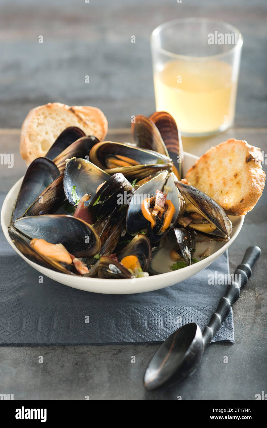 Le cozze con il sidro di mele e pancetta Foto Stock