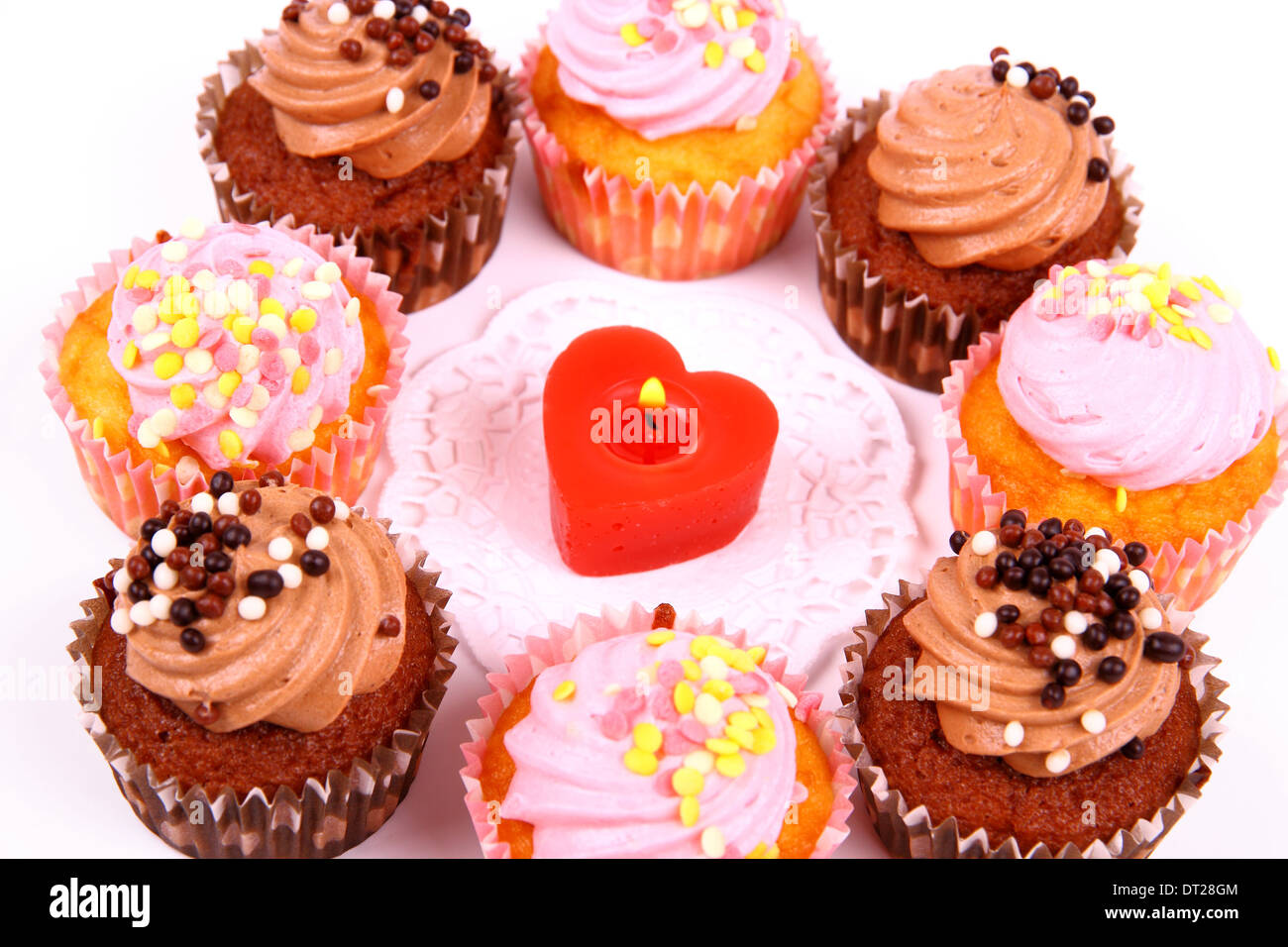Cioccolato e rosa tortine con candela cuore isolato, close up Foto Stock