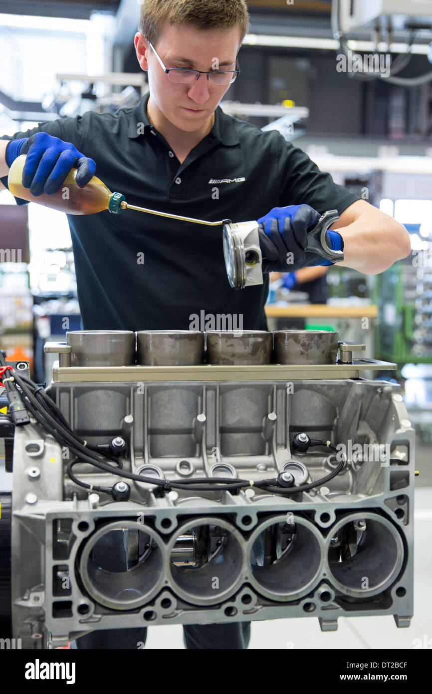 La Mercedes-AMG di produzione del motore in fabbrica Germania engineer si applica olio lubrificante ai cilindri per pistoni di 6.3 litri V8 motore Foto Stock