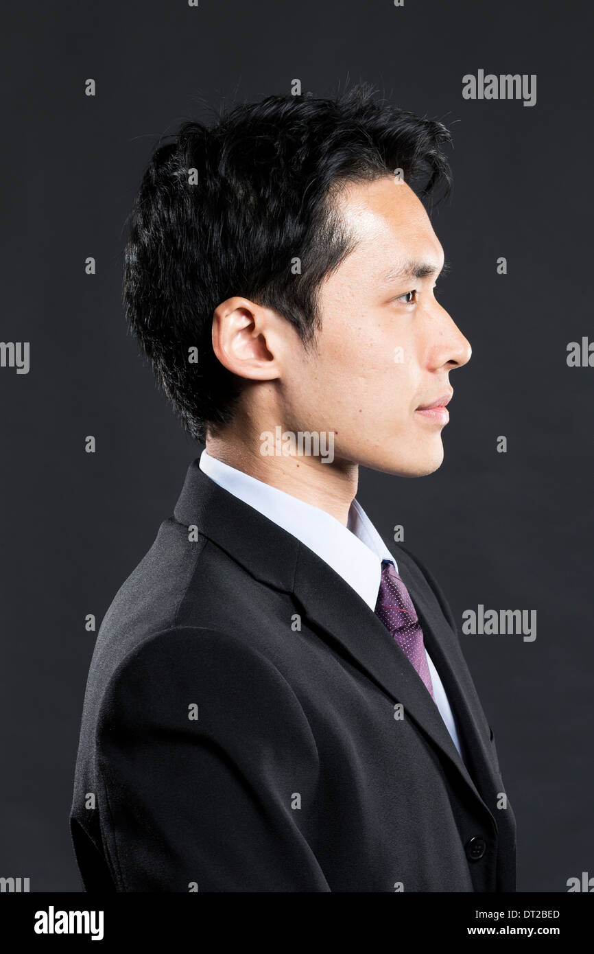 Ritratto di un elegante Asian business man. Sfondo grigio scuro Foto Stock
