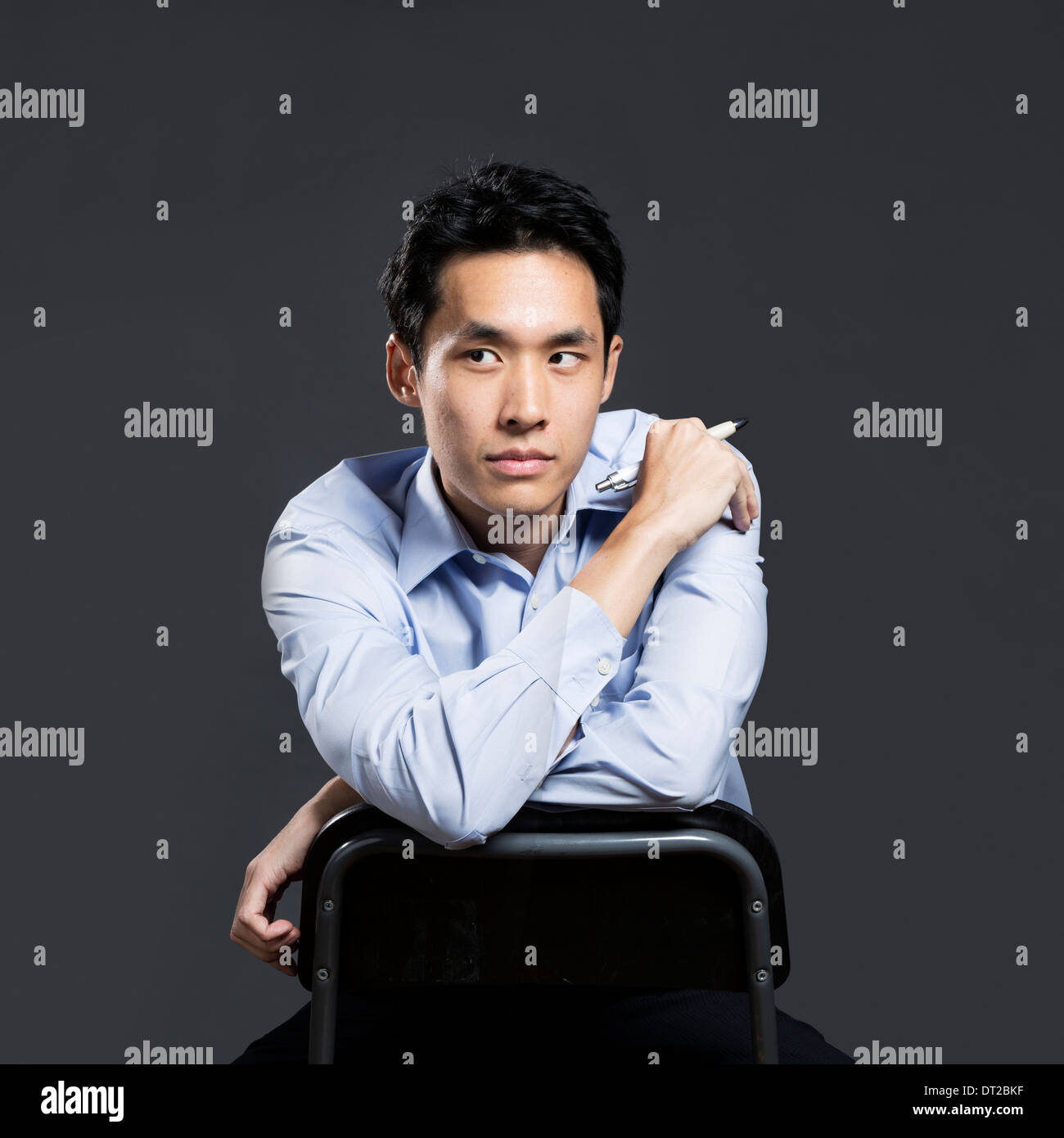 Ritratto di un elegante Asian business man. Sfondo grigio scuro Foto Stock