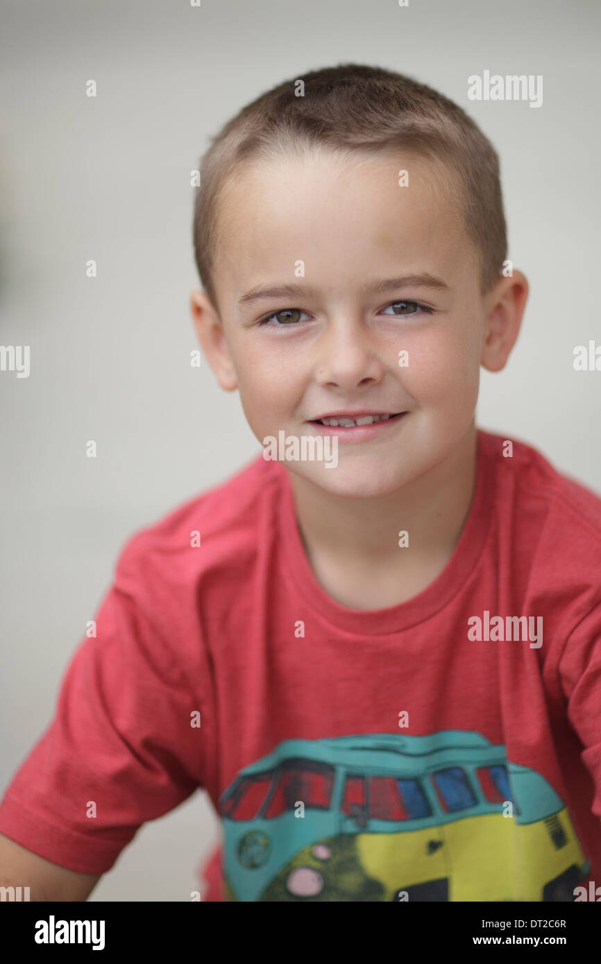 Un ragazzo che sorride guardando la telecamera, colori luminosi Foto Stock