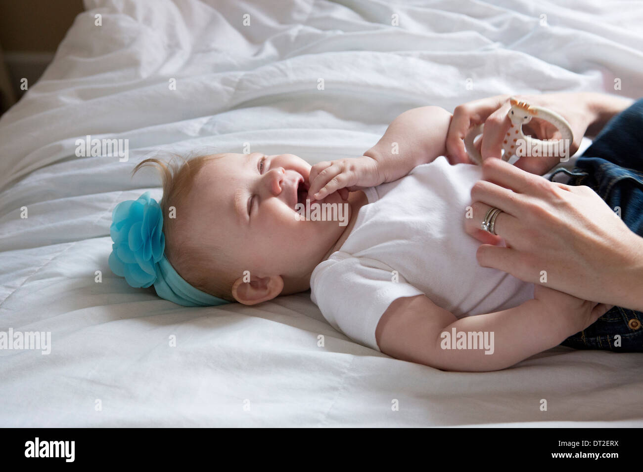 Baby girl (6-11 mesi) sdraiato sul letto Foto Stock