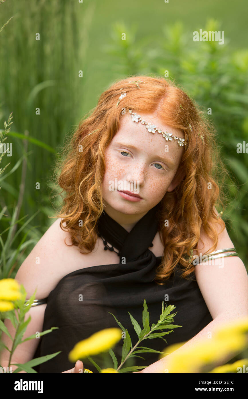 Ritratto di ragazza (10-11) seduto in erba Foto Stock