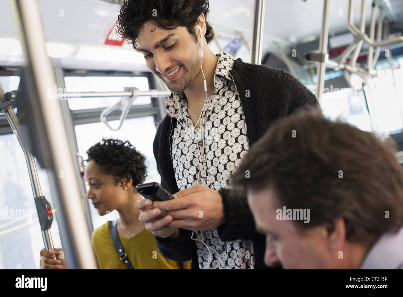 New York City Park persone uomini e donne su un autobus del trasporto pubblico mantenendo in contatto un giovane uomo di controllare il suo telefono cellulare Foto Stock