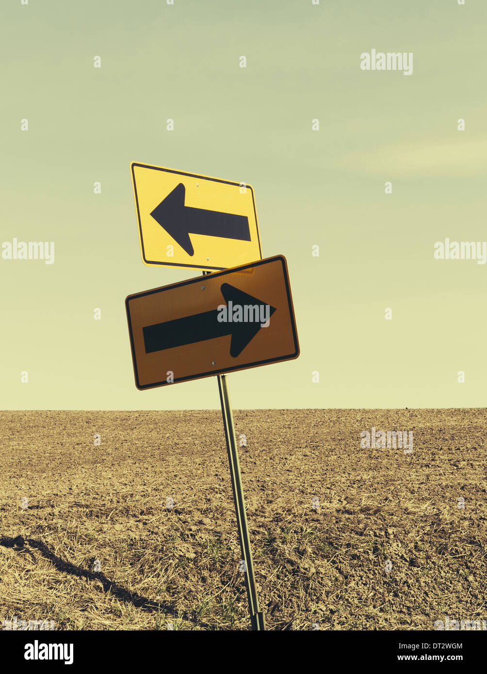 Freccia direzionale segno terreno coltivato in background nei pressi di Pullman Foto Stock
