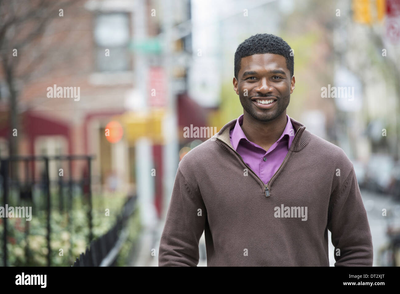 Un giovane uomo che indossa una maglietta viola e jersey sorridente Foto Stock