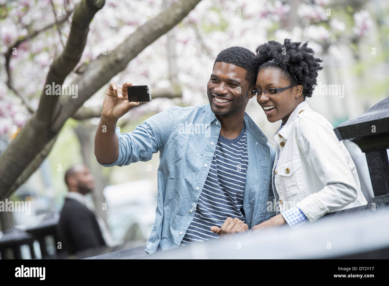 Città in primavera un stile di vita urbano un paio di fianco a fianco guancia a guancia prendere una fotografia con un palmare telefono cellulare Foto Stock
