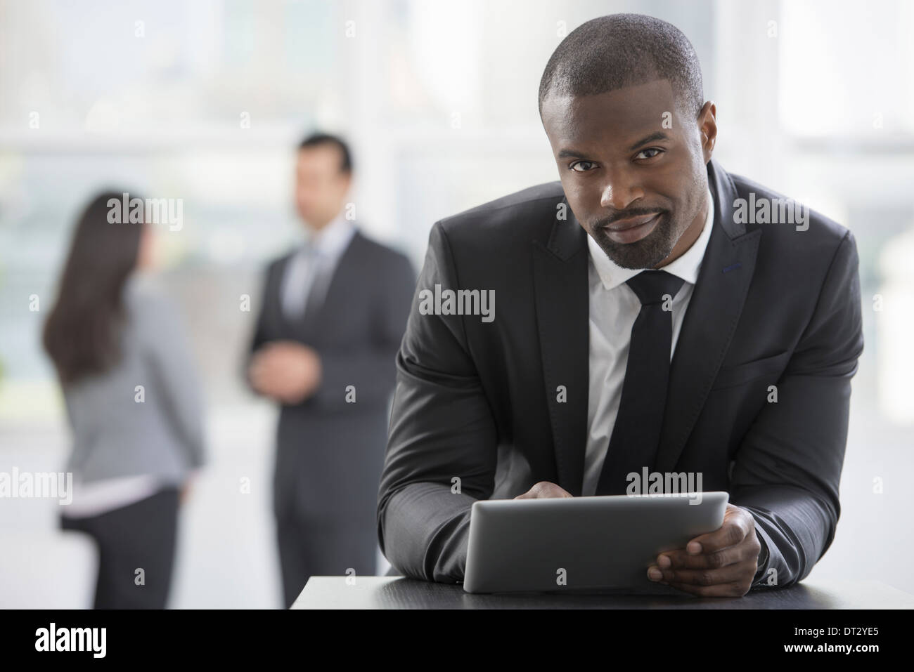 I giovani professionisti al lavoro di un uomo in un business suit utilizzando una tavoletta digitale Foto Stock