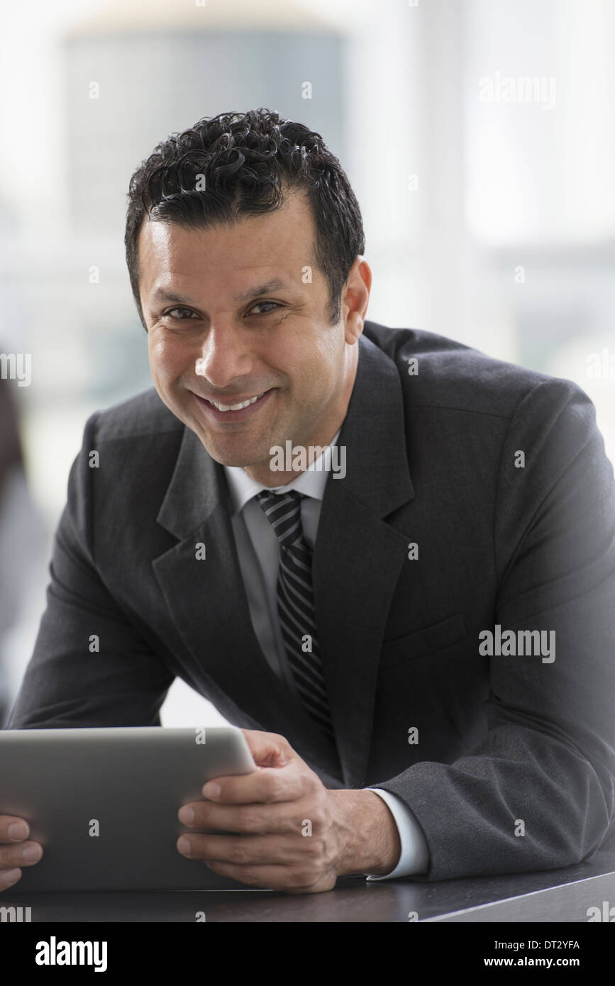 I giovani professionisti al lavoro di un uomo in un business suit utilizzando una tavoletta digitale Foto Stock