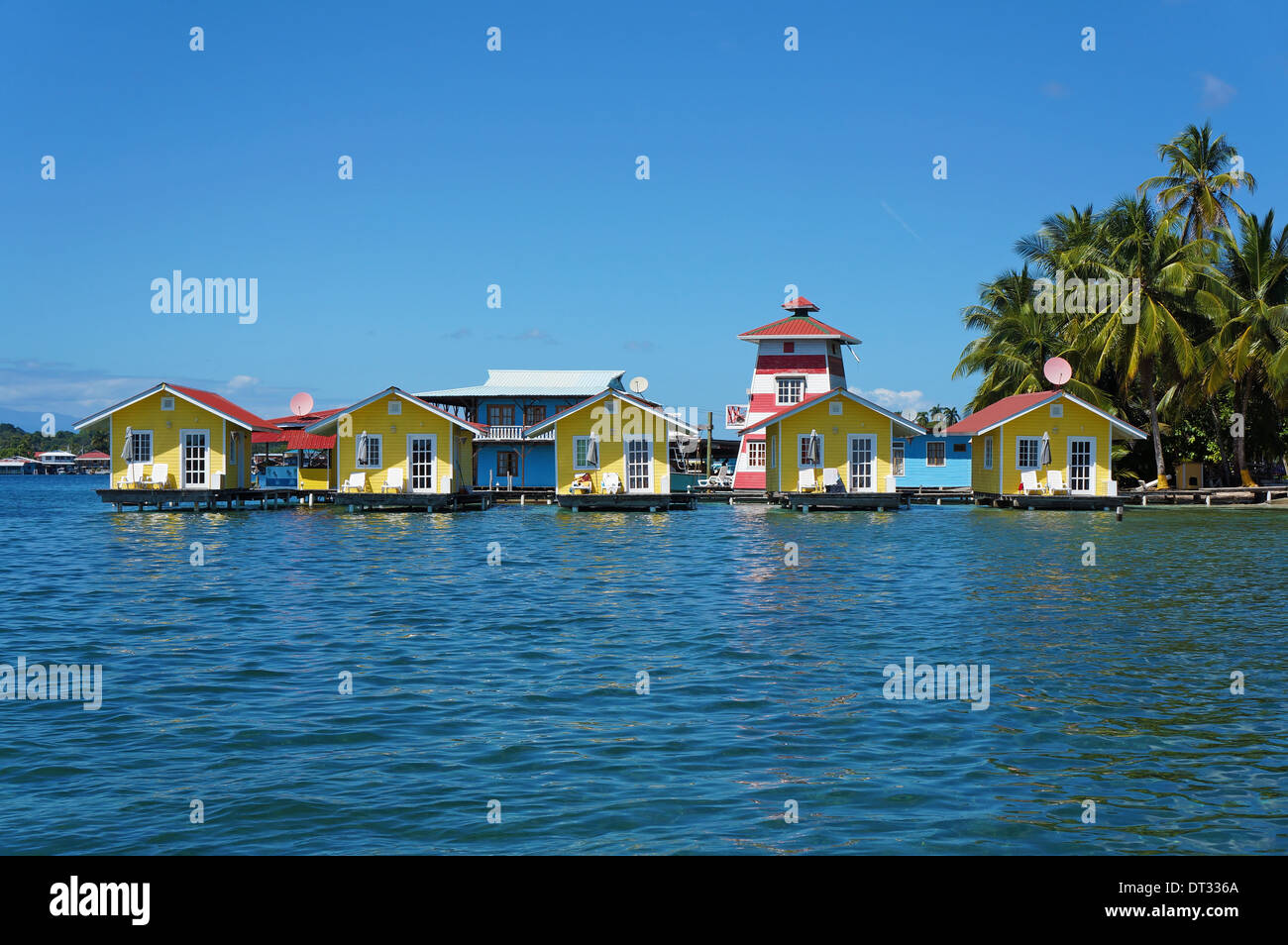 Vacanza tropicale bungalows sull'acqua con alberi di noce di cocco sul Mare dei Caraibi, Bocas del Toro, Carenero isola, Panama Foto Stock