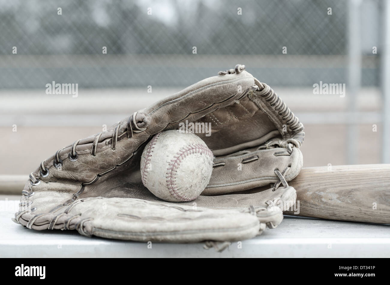 America del gioco di baseball con nel guanto con bat sul banco di lavoro. Campo da Baseball in background. Foto Stock