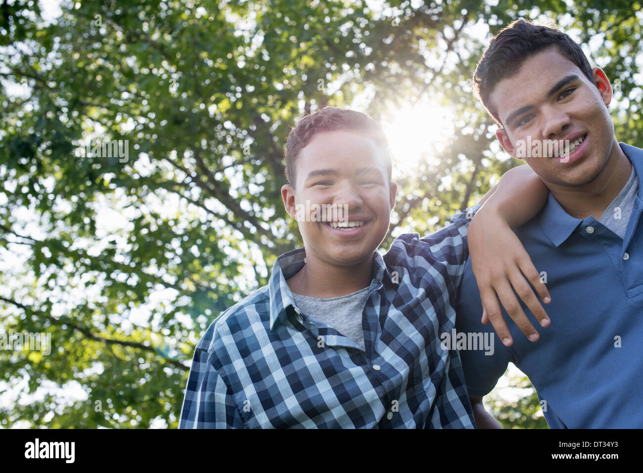 Due giovani uomini all'aperto uno con il suo braccio intorno alle spalle dell'altro Foto Stock