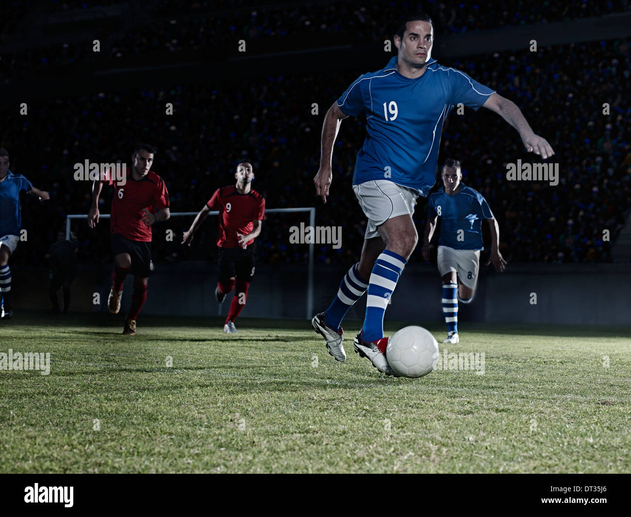 I giocatori di calcio a caccia di palla sul campo Foto Stock