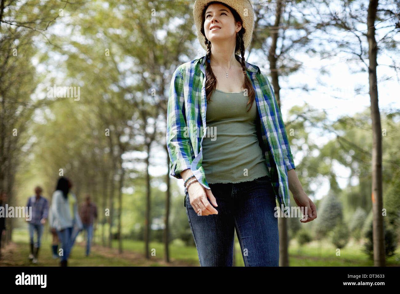 Una ragazza in un cappello di paglia a piedi nei boschi Foto Stock