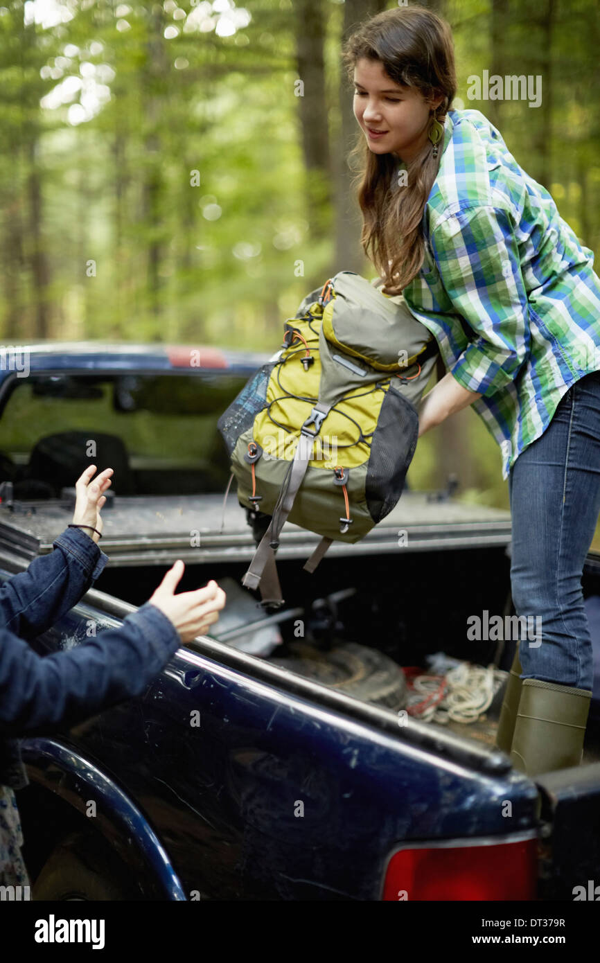 Donna zaini di scarico dal carrello di prelievo Foto Stock