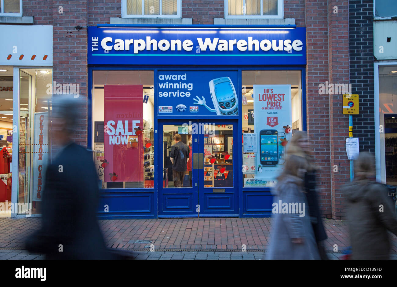 La gente che passa un segno sulla facciata anteriore o facciata del Carphone Warehouse negozio o supermercato Macclesfield Cheshire England Regno Unito Foto Stock