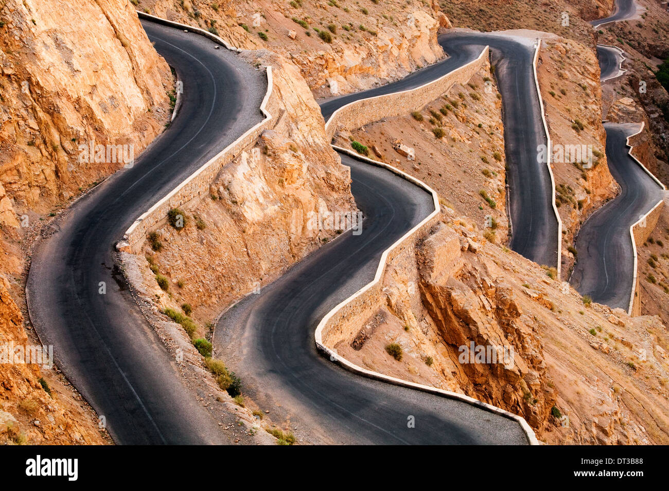 Molto ventoso road fino le rocciose montagne Atlas dalla valle di Dades, Marocco Foto Stock