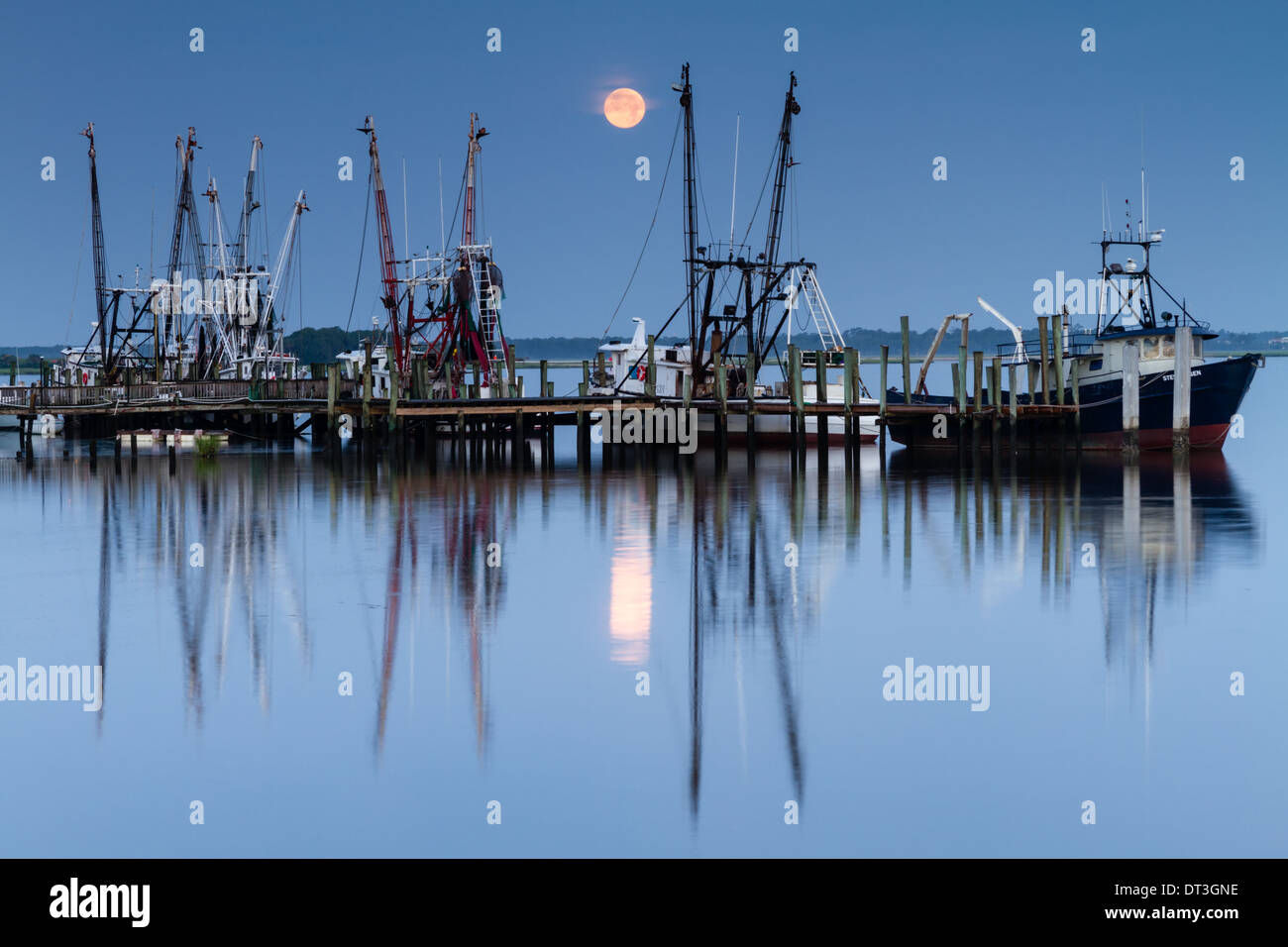 Gamberetti in corrispondenza di un dock con la luna piena impostazione in background. Foto Stock