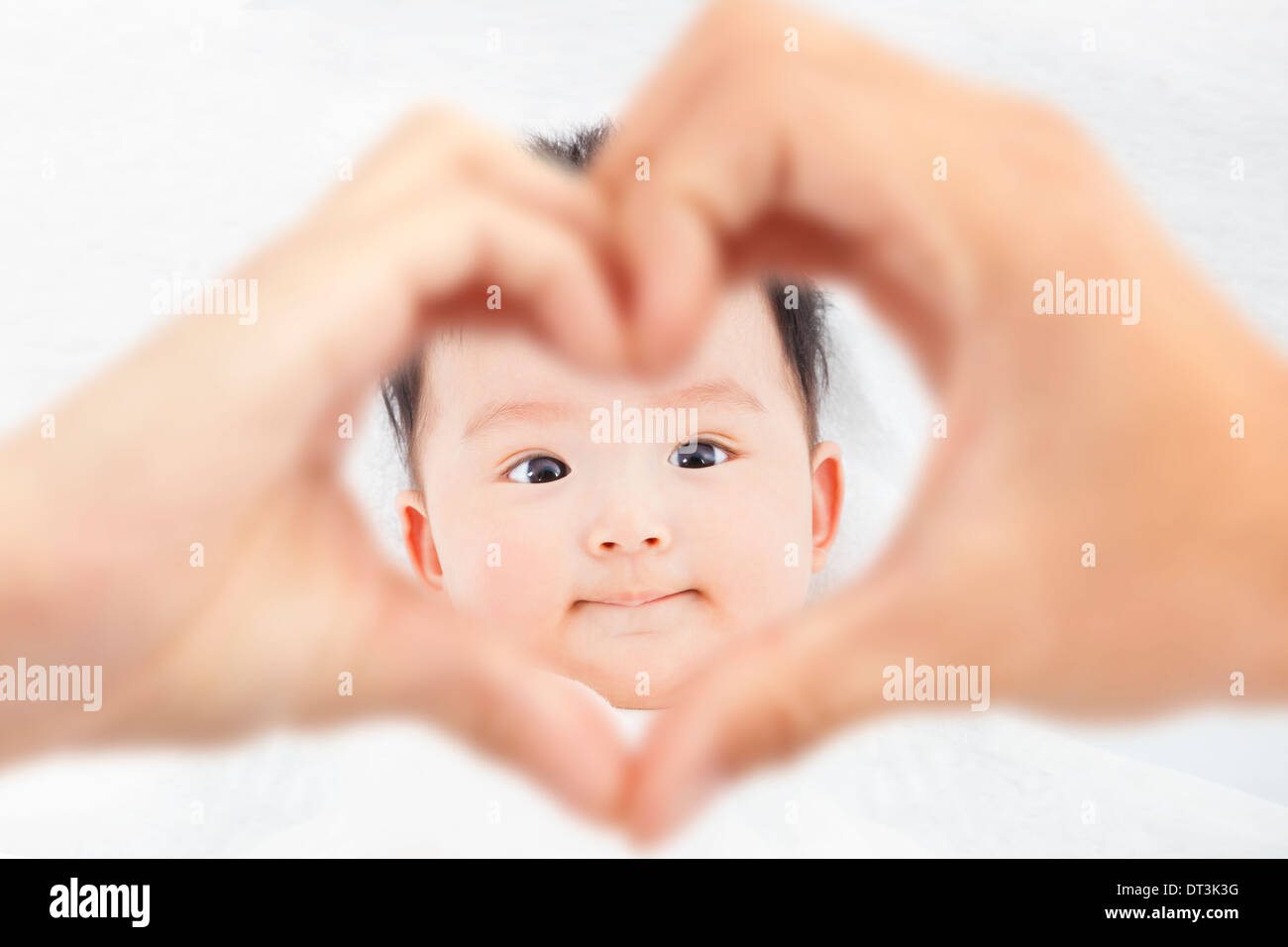 Carino e sorridente infantile con i genitori amore mani Foto Stock