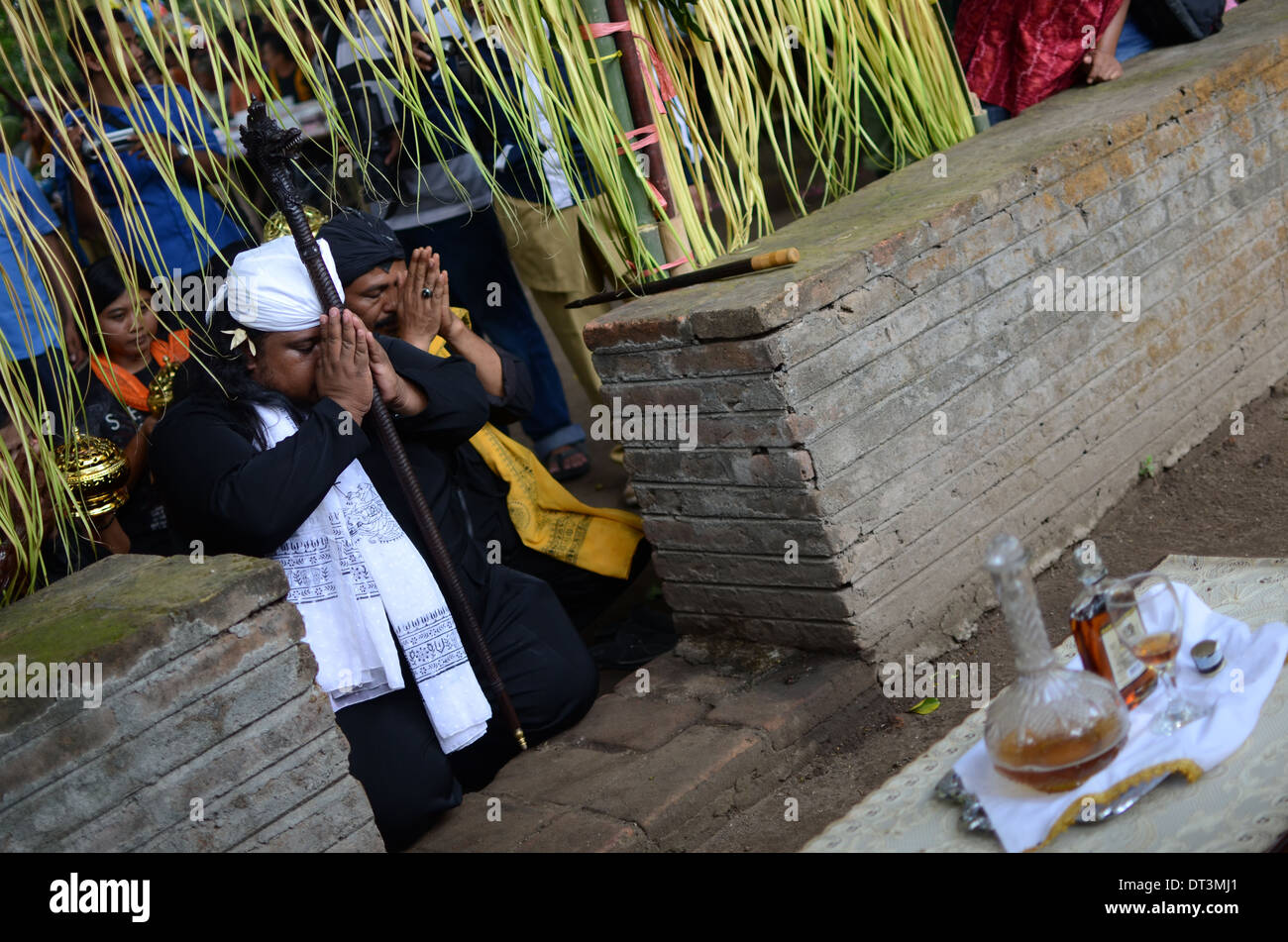 Gli anziani del villaggio che portano il rituale delle offerte di liquore presso la tomba di Prabu Anom Doko nel villaggio. Foto Stock